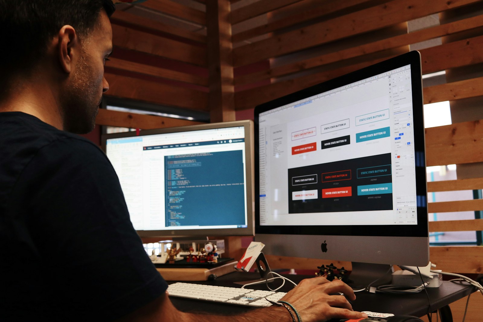Designing and coding a custom web app — screens on one monitor, code on the other